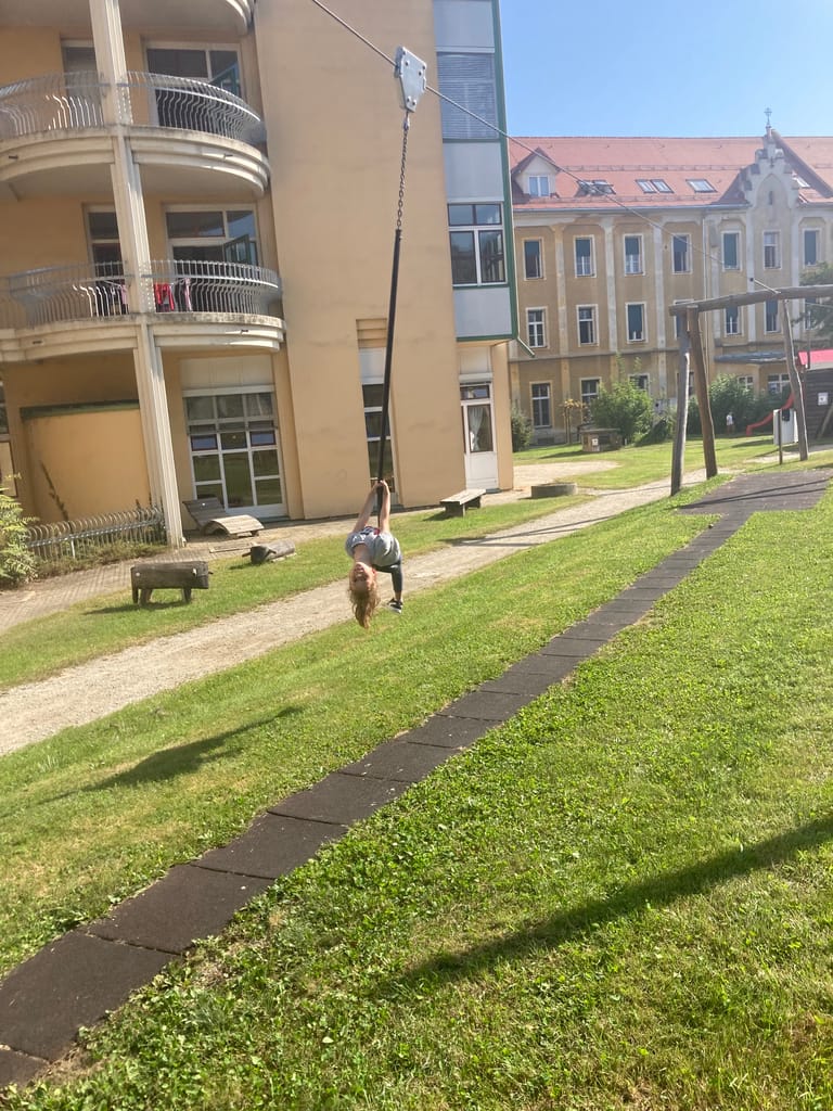 Kind fährt mit Flying Fox über den Schulhof