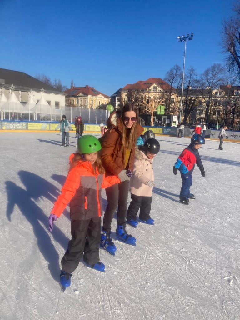 Kinder fahren mit Lehrerin am Eis.