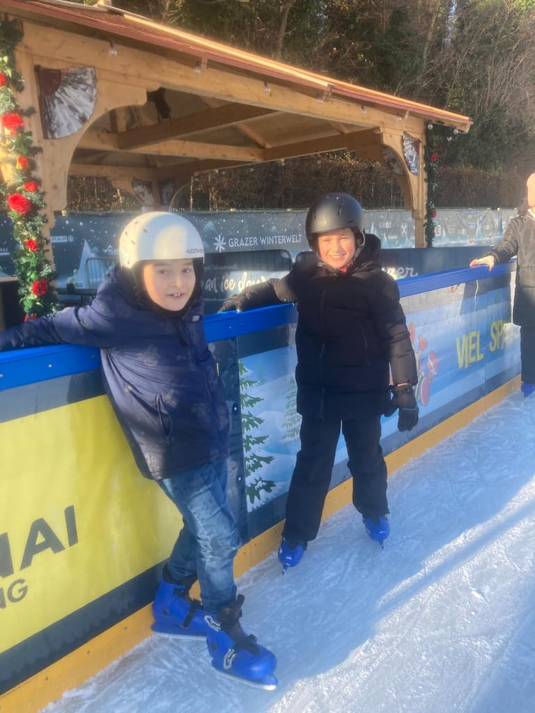 2 Kinder stehen am Eis und lächeln.