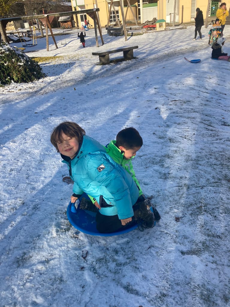 Kinder fahren zu zweit mit einem Bob.