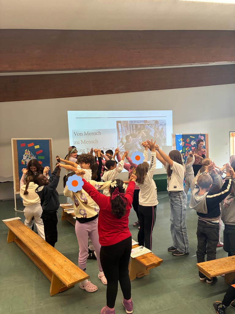 Kinder bauen eine Brücke mit den Händen.