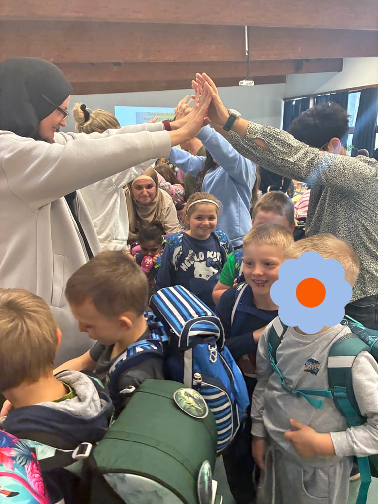 Kinder lächeln, während sie durch Spalier gehen.