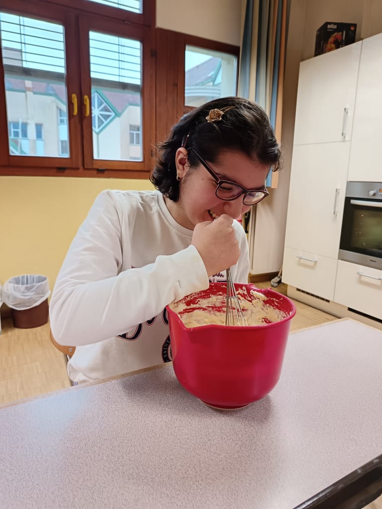 Jugendliche rührt in einer roten Schüssel.