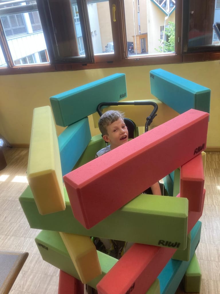 Kind ist von Bausteinen umringt.