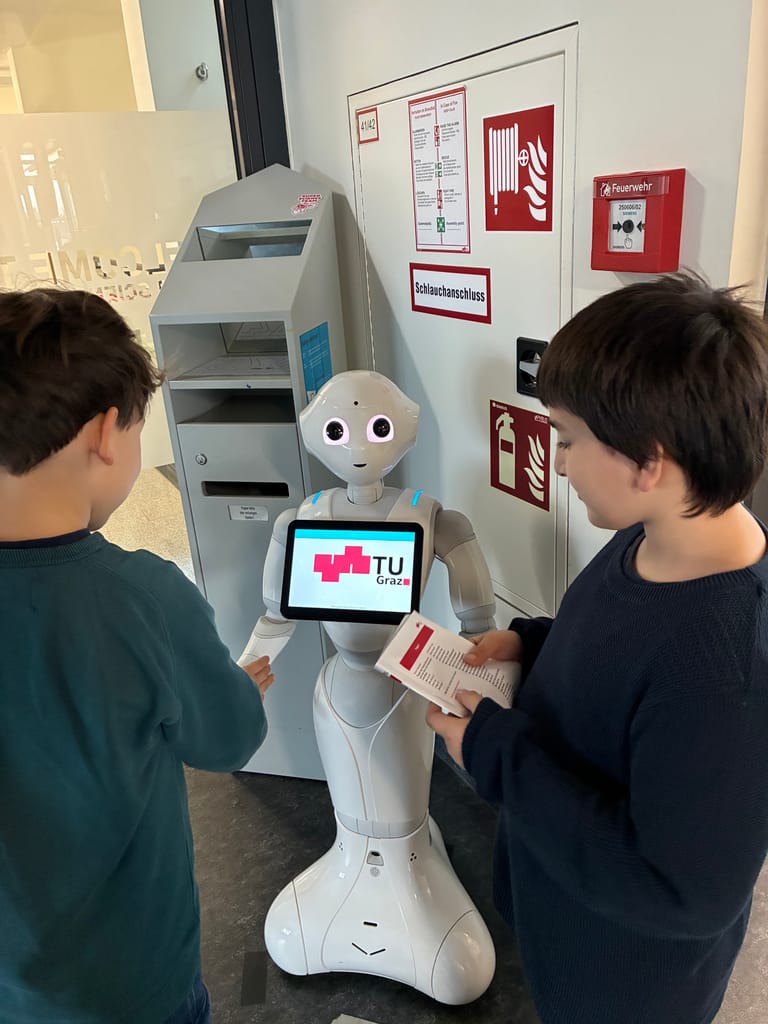 Kinder sprechen mit Roboter und geben ihm Befehle.