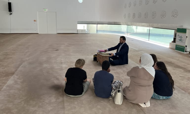 4 Kinder sitzen in einem hellen Raum in der Moschee.