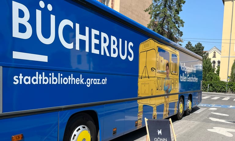 Blauer Bus mit Liegestuhl davor