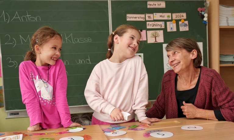 2 Kinder lernen mit Lehrerin und lächeln