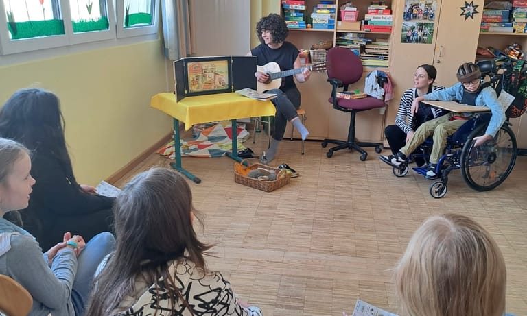 Lehrerin singt mit Gitarre