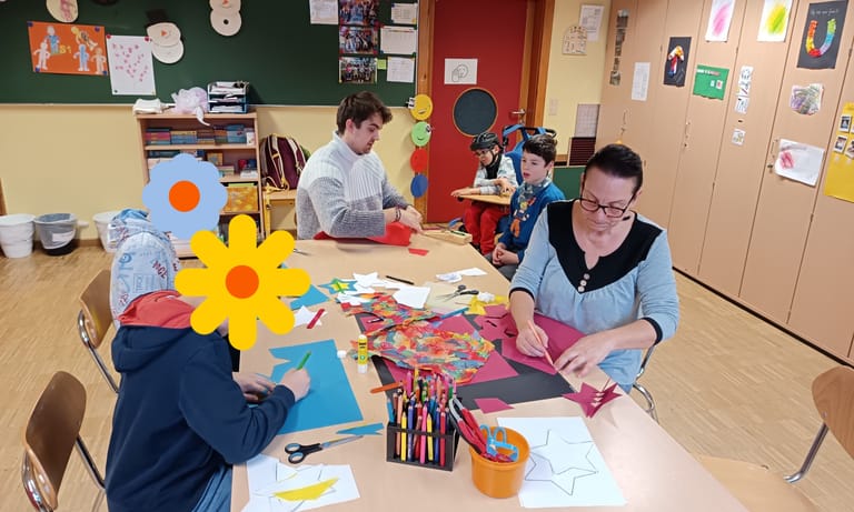 Kinder basteln gemeinsam an einem Tisch