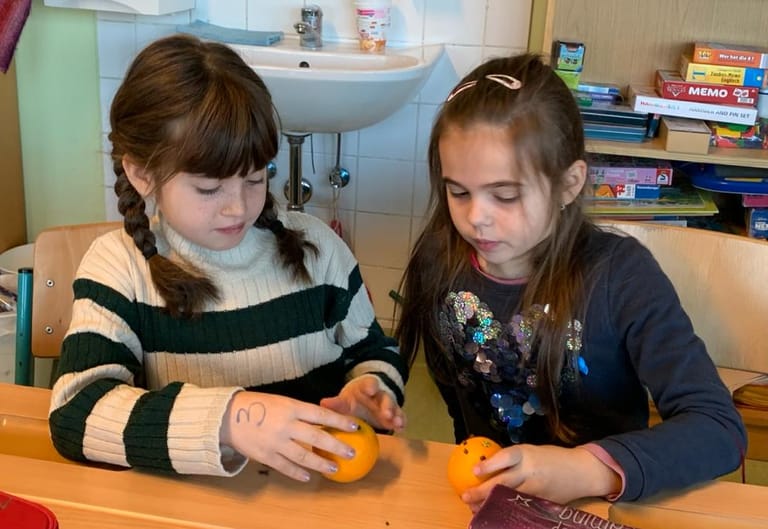 Zwei Kinder machen Gewürzorangen.