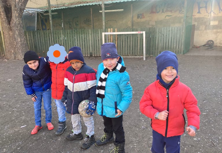 Kinder stehen nebeinander am Fußballplatz.