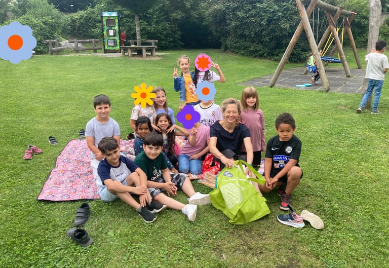 Kinder machen im Schulhof ein Picknick.