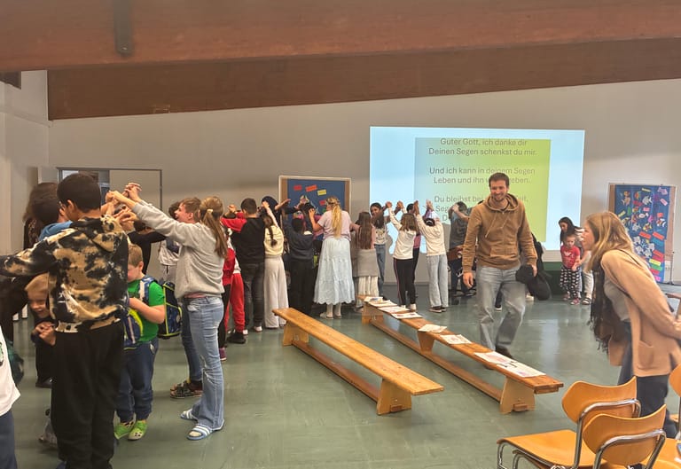 Kinder stehen Spalier und die Erstklässlerinnen gehen durch.