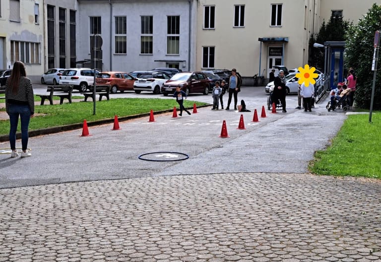 Kinder laufen einen Slalom im Schulhof.