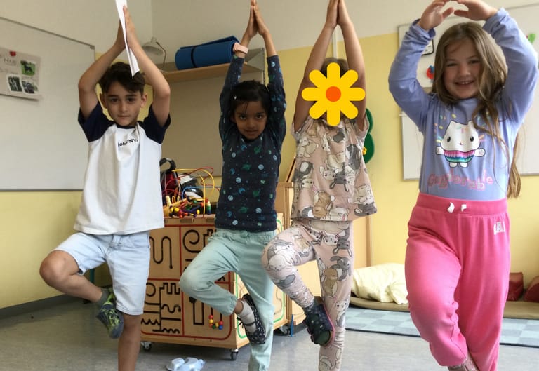 4 Kinder stehen in der Yoga-Baum-Pose