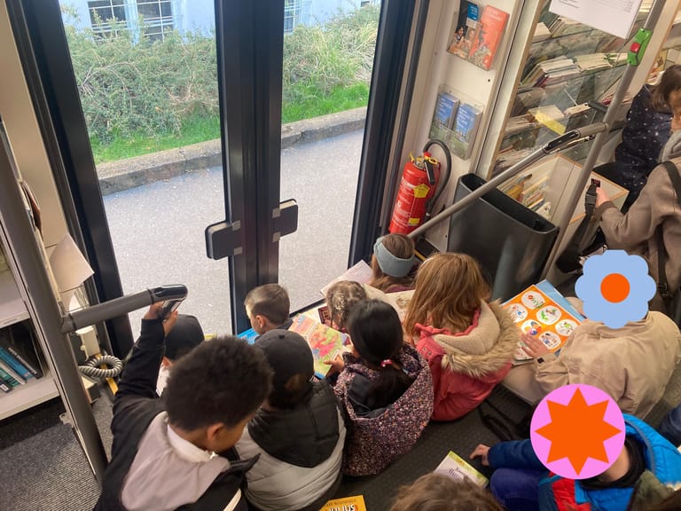 Kinder lesen vertieft in Büchern auf der Stiege in einem Bus
