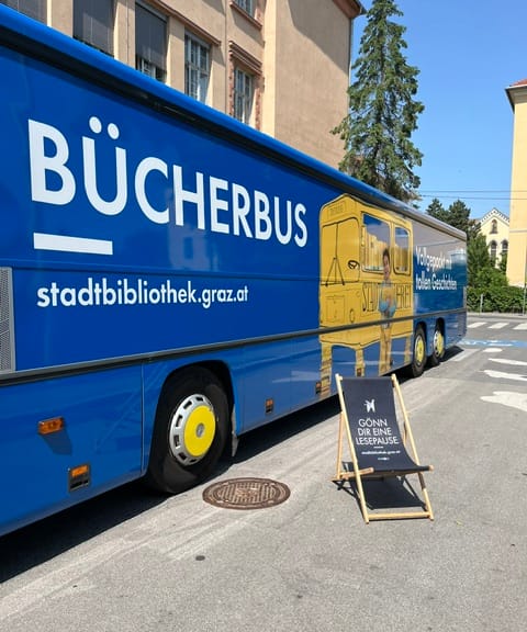 Liegestuhl steht vor Bücherbus