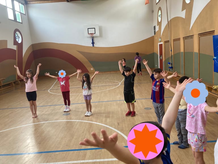 Kinder stehen im Kreis und strecken die Hände hoch