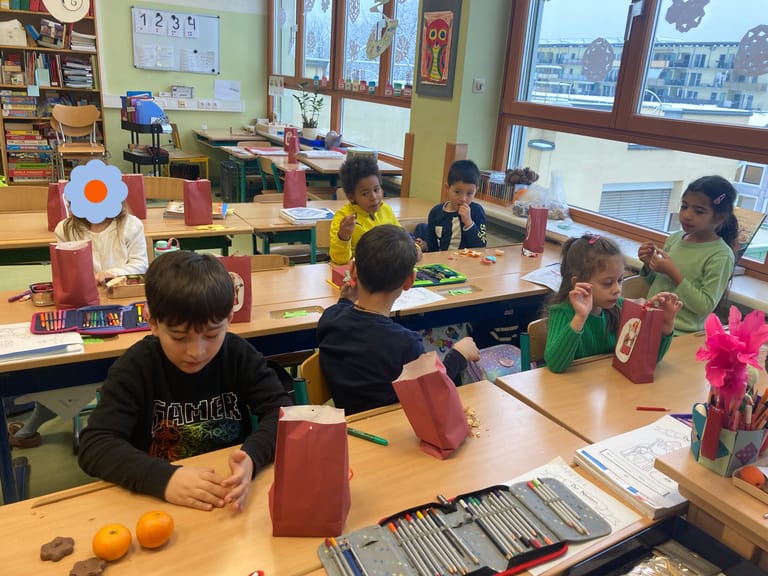 Kinder öffnen ihr Sackerl vom Nikolaus.