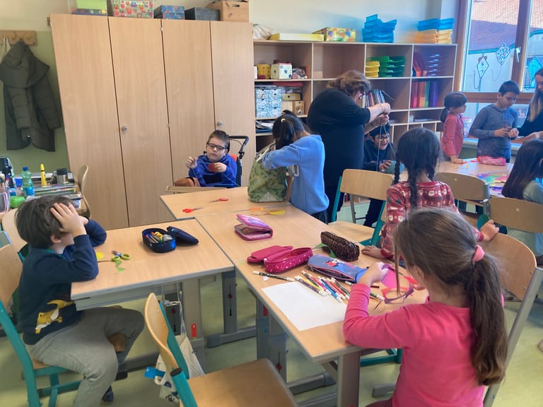 Kinder basteln etwas Weihnachtliches.