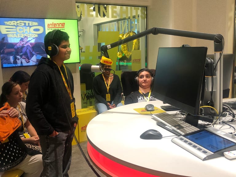 Kind spricht in Radio-Mikrofon.