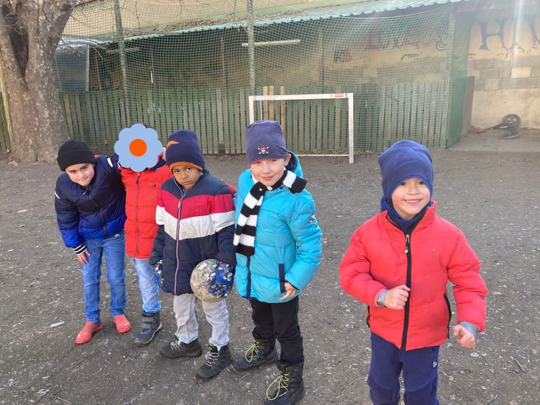 Kinder stehen nebeinander am Fußballplatz.