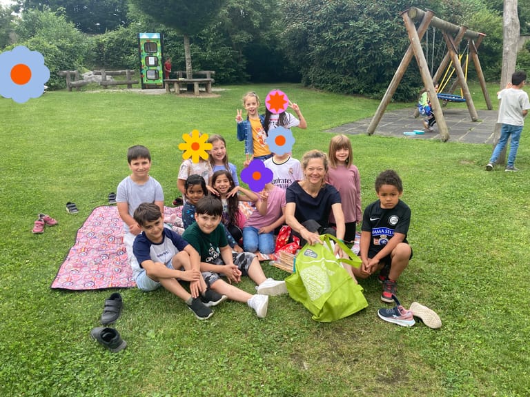 Kinder machen im Schulhof ein Picknick.