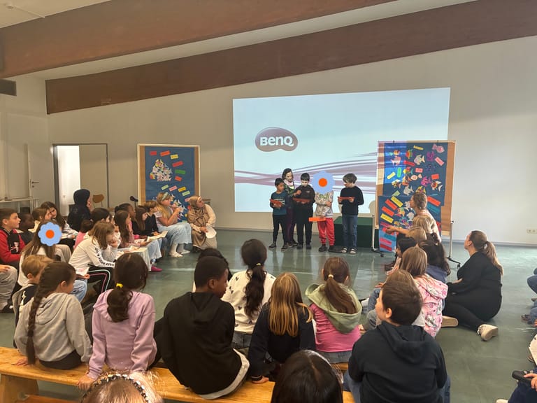 4 Kinder tragen vorne etwas vor, viele Kinder hören zu.