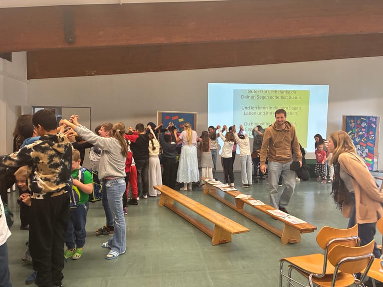 Kinder stehen Spalier und die Erstklässlerinnen gehen durch.