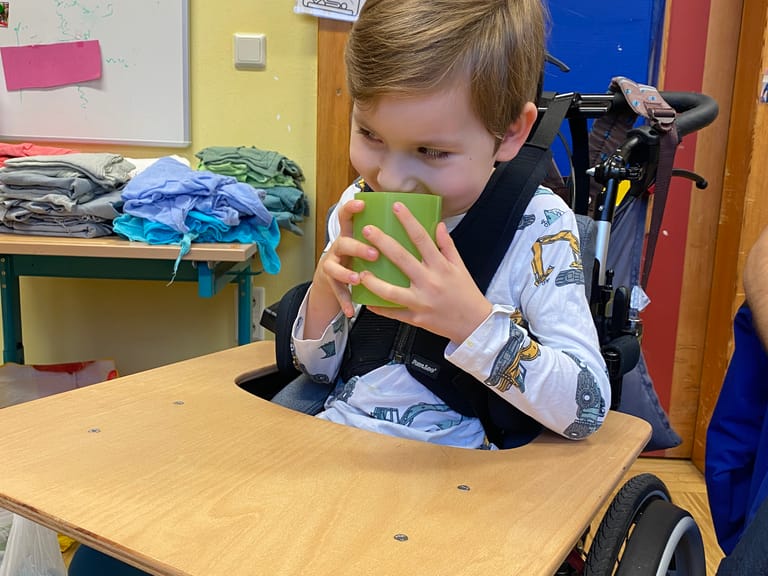 Kind trinkt aus Becher beim Theaterspielen.