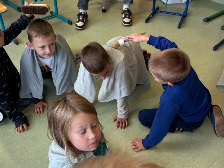 Buben spielen Theater am Boden in der Klasse.