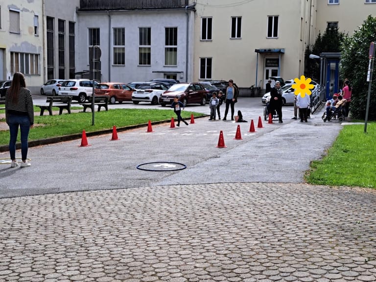 Kinder laufen einen Slalom im Schulhof.