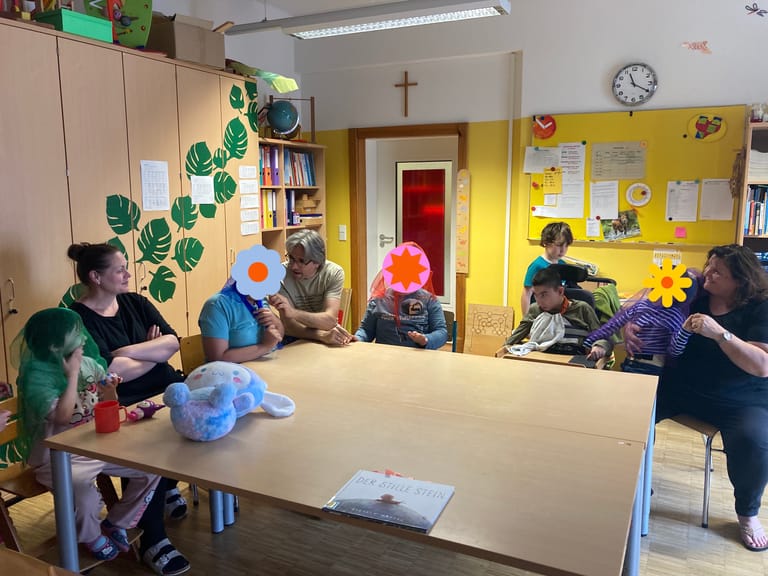 Kinder sitzen in einem Kreis und lauschen einer Geschichte.