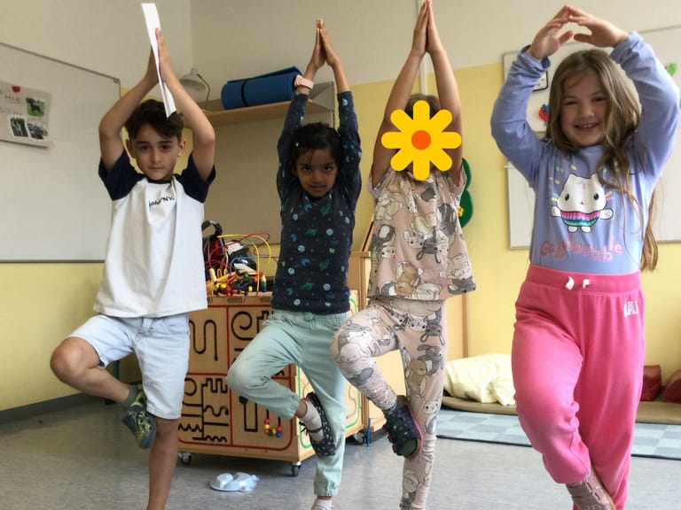 4 Kinder stehen in der Yoga-Baum-Pose
