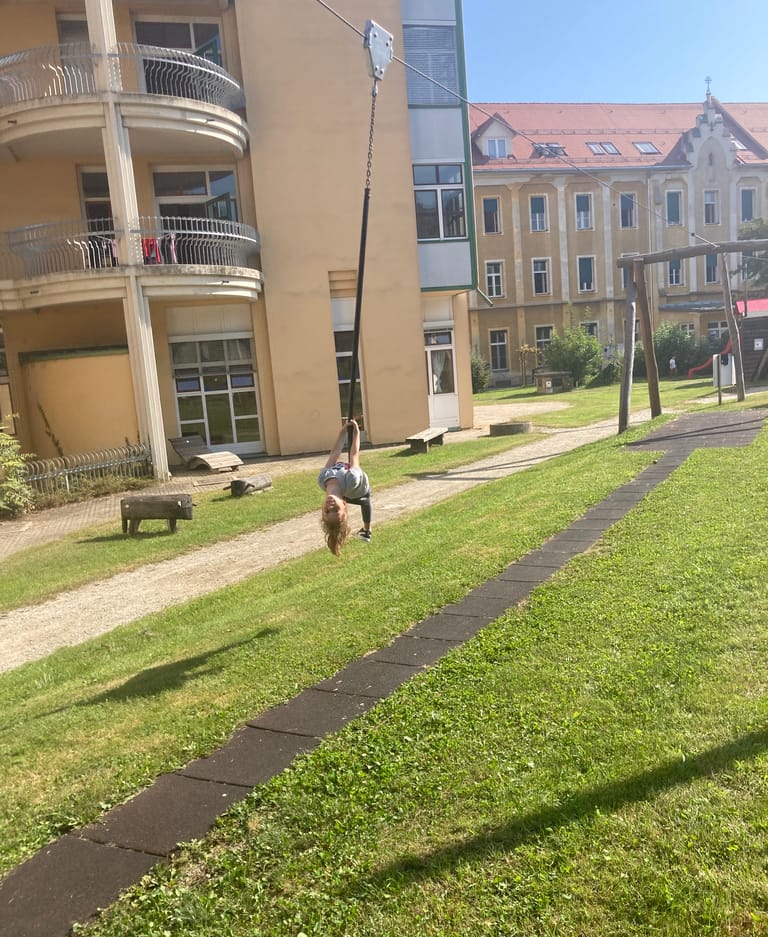 Kind fährt mit Flying Fox über den Schulhof