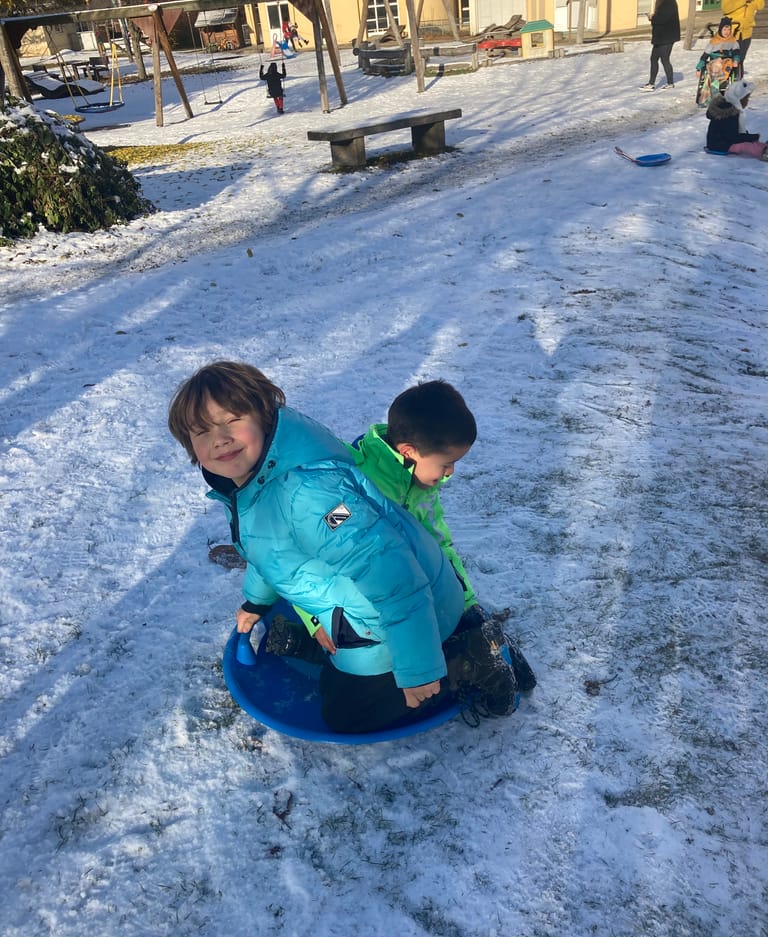 Kinder fahren zu zweit mit einem Bob.